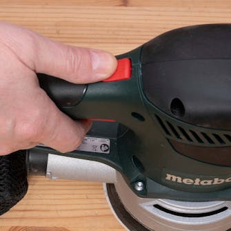 Eksentersliper test: Den røde turboknappen, som sitter oppå håndtaket, tilsidesetter den forutvalgte hastigheten og setter farten helt opp Eksentersliper test: Den røde turboknappen, som sitter oppå håndtaket, tilsidesetter den forutvalgte hastigheten og setter farten helt opp